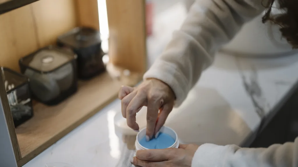 Cream being applied from a small container