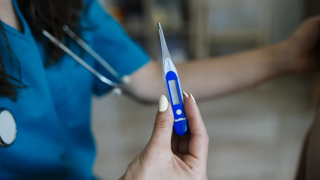 A healthcare professional taking a patient's temperature