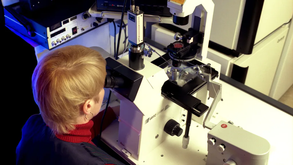A researcher working at a microscope